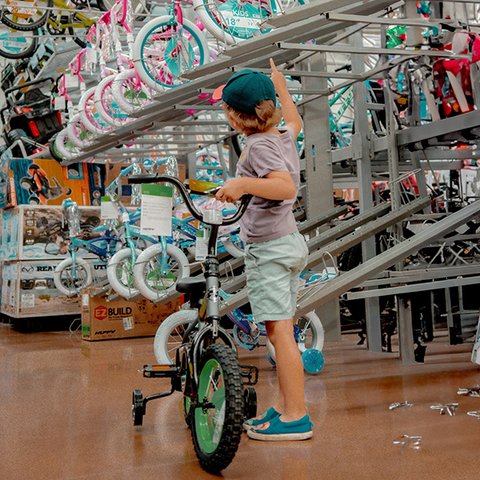 Kind mit Kinderrad in Fahrradladen