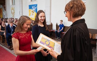 Pfarrerin mit zwei Konfirmandinnen in Kirche