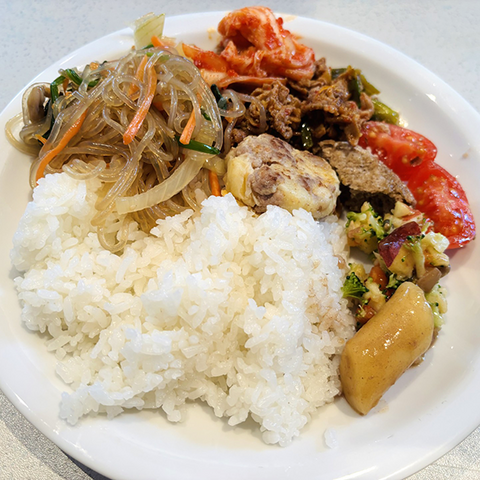 Teller mit koreanischen Spezialitäten und Reis.