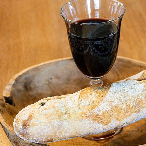 Glas mit Rotwein und Holzschale mit Brot