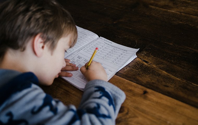 Kind schreibt in Rechenheft
