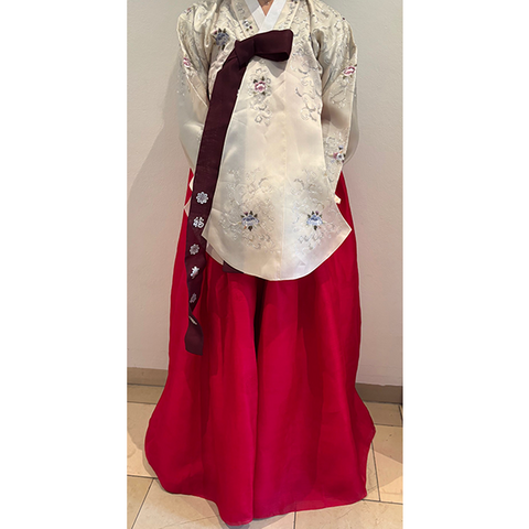 Hanbok mit rotem Rock und cremefarbenem bestickten Oberteil.