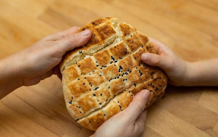 Drei Hände halten Fladenbrot