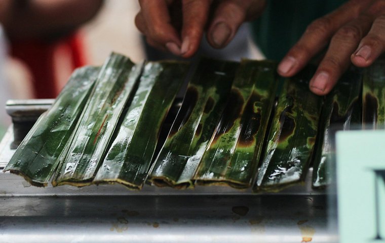 Hände falten geflämmtes Bananenblatt 